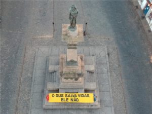 Foto - Vista aérea - Faixa em apoio ao SUS exposta aos pés do monumento ao Mártir da Inconfidência, O Tiradentes / Crédito - Foto: Felipe Muniz